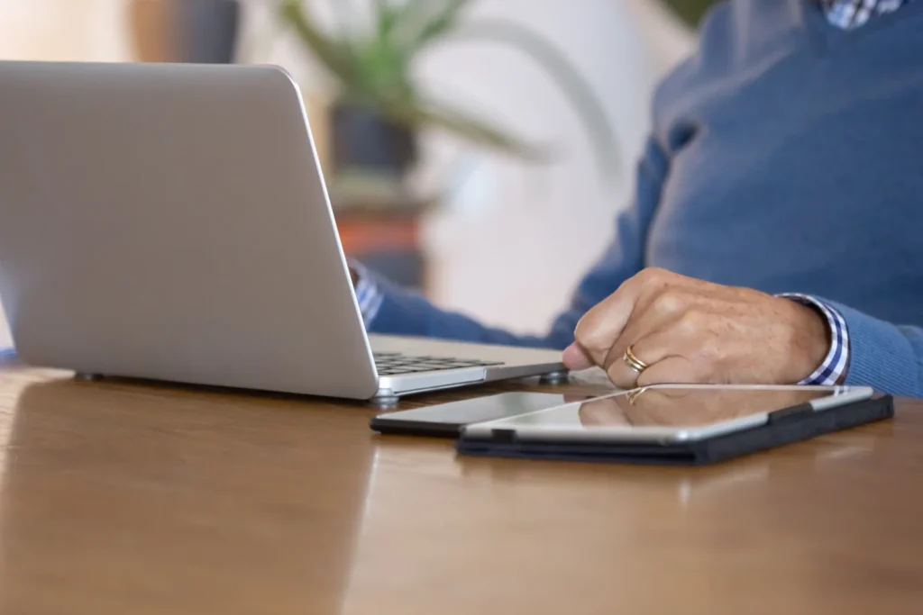 Amministratore di società al lavoro sul portatile con tablet e smartphone sulla scrivania